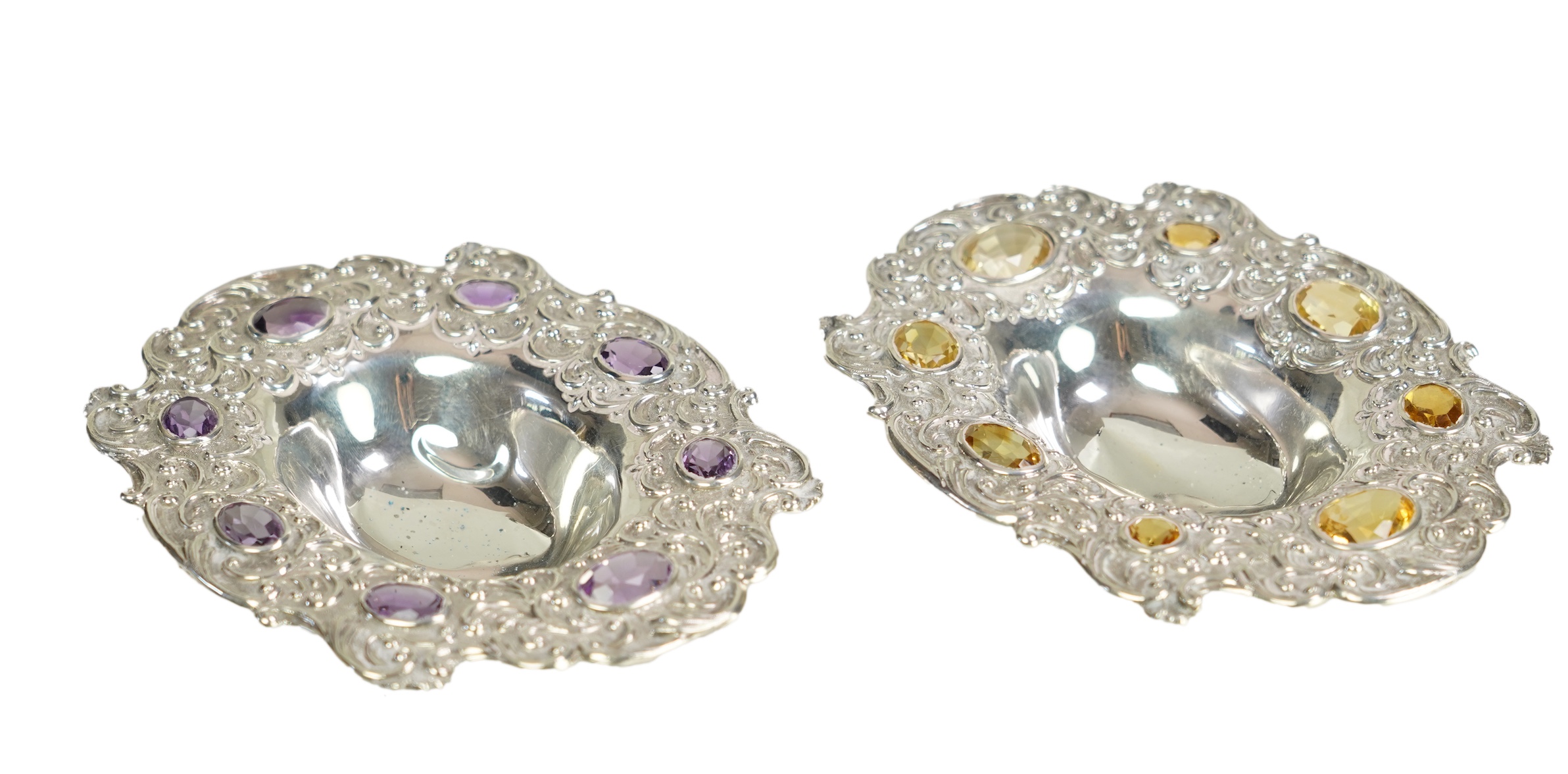 Two unusual late Victorian repousse silver dishes, by Daniel & John Welby, one border inset with eight oval cut amethysts, the other with eight oval cut citrines